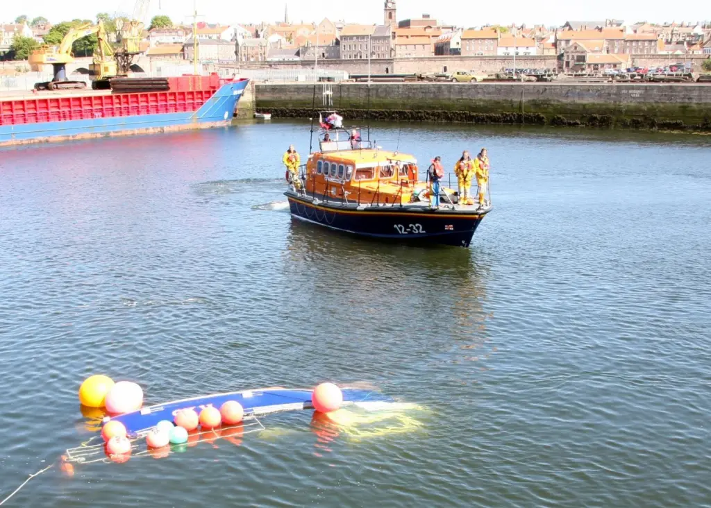 Berwick all-weather lifeboat with the upturned fishing boat. Credit: RNLI/Michael Avril