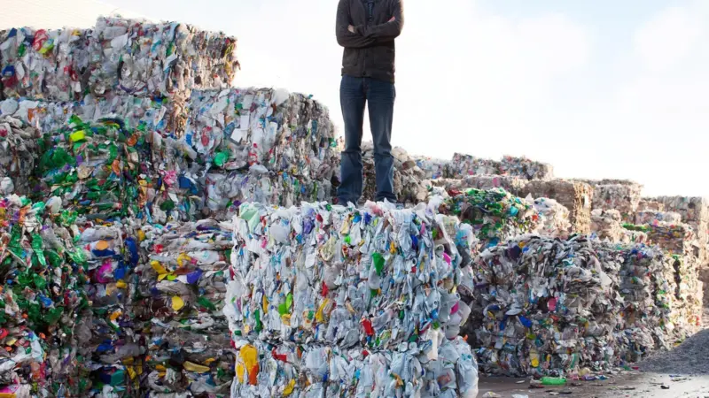 Tom Doman, Innovations Manager at Ecover on a bale of plastic waste