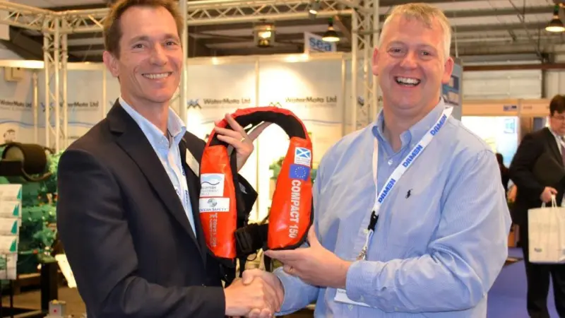 Mark Hart presents one of the lifejackets to Derek Cardno, Marine Safety and Training officer at the SFF