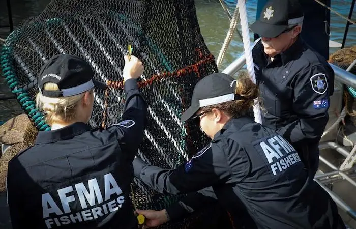Fisheries officers inspect a turtle excluder device Photo: AFMA