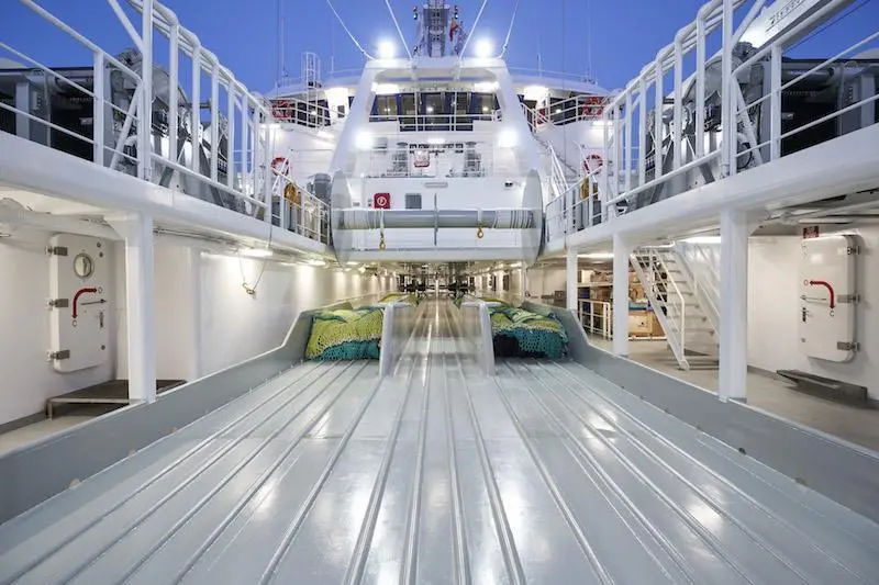 The deck is laid out with three full length trawl lanes, and a single net drum mounted over the deck