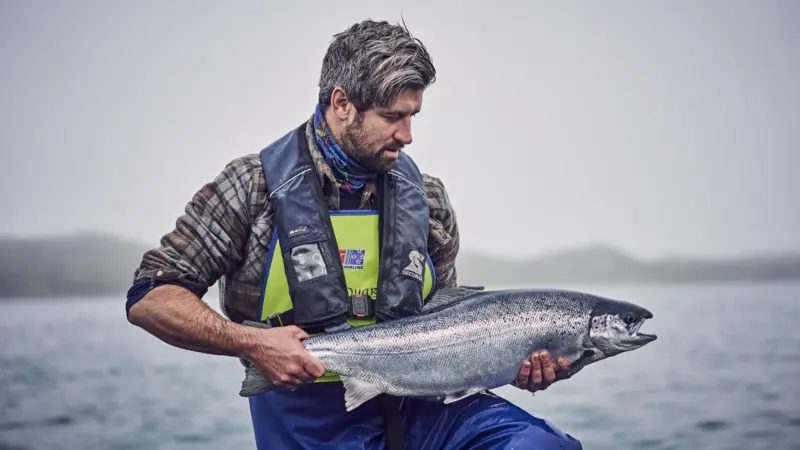 Loch_Duart_husbandryman_holding_salmon