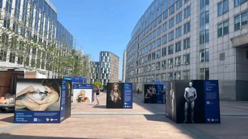 Photographic exhibition of celebrities posing naked with fish displayed outside the EU parliament in Brussels