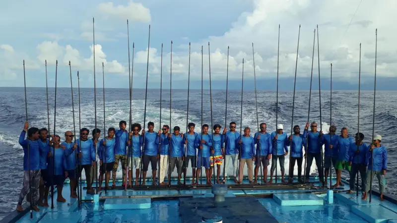 One-by-one tuna fishers standing on a fishing vessel at sea