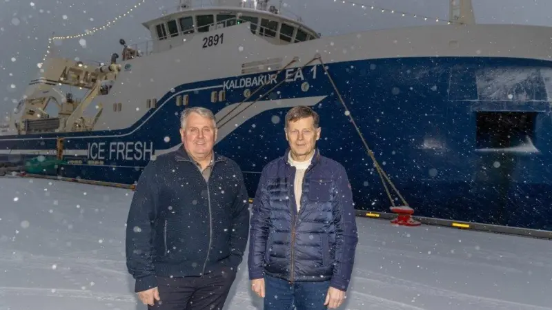 Kristján Vilhelmsson and Thorsteinn Már Baldvinsson with the trawler Kaldbakur EA 1 in the background