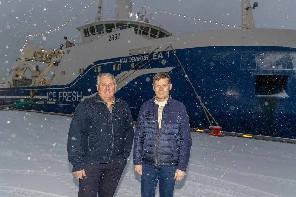 Kristján Vilhelmsson and Thorsteinn Már Baldvinsson with the trawler Kaldbakur EA 1 in the background