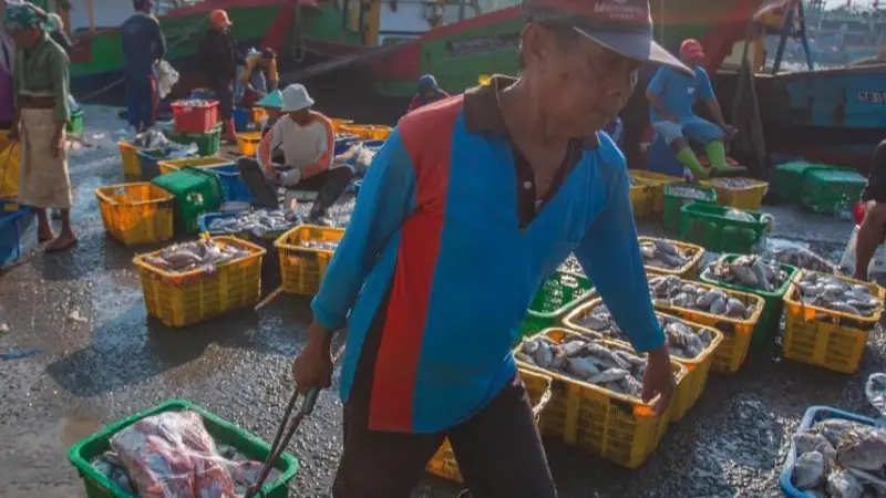The image shows an Indonesian fisher on board a vessel