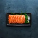 Sashimi laid on a black oblong plate