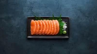 Sashimi laid on a black oblong plate