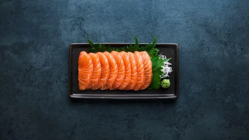 Sashimi laid on a black oblong plate